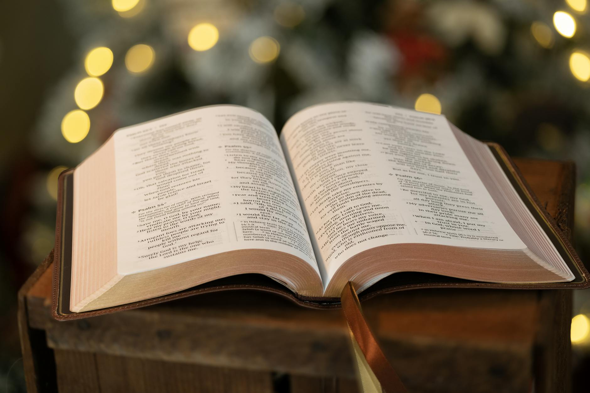 open bible with blurred christmas lights in background