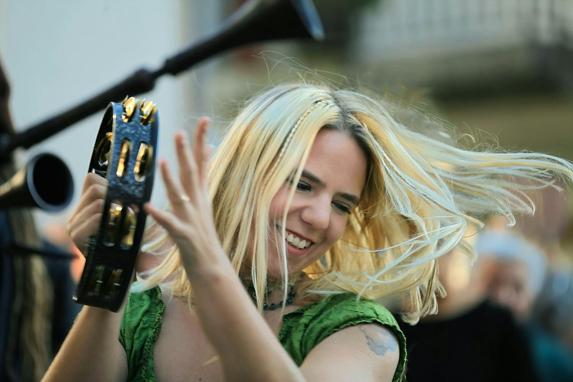 woman in green blouse playing a tambourine
